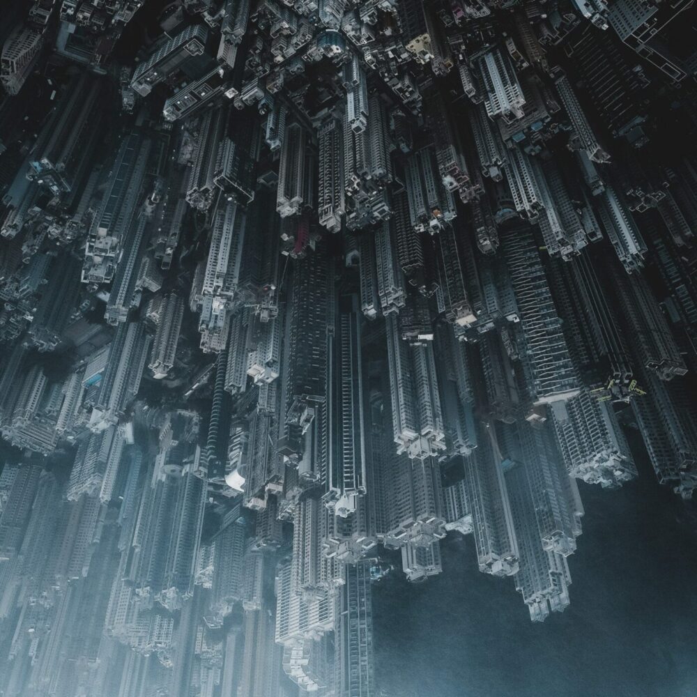 The City Falls art print presents a surreal upside-down cityscape with numerous skyscrapers densely packed against a foggy backdrop, creating an illusion of an urban jungle suspended mid-air.