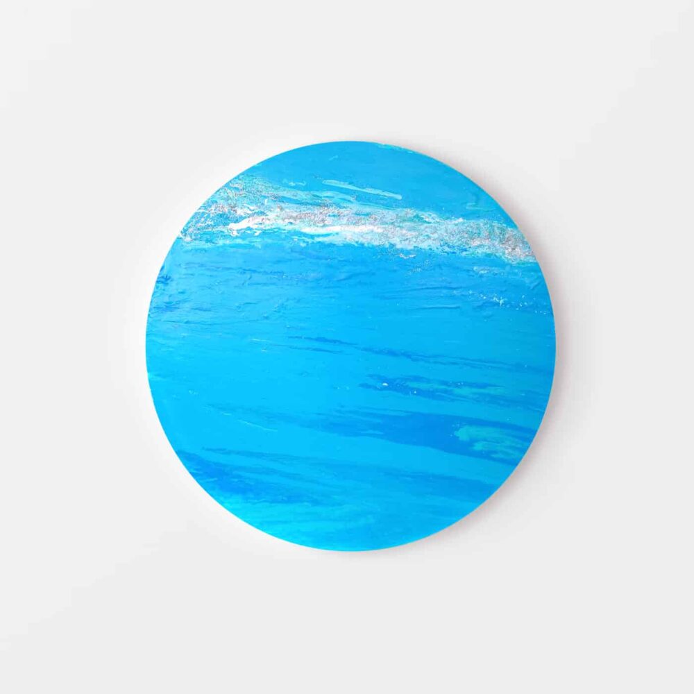 The Uranus Glacial art print displays a circular depiction of a vibrant blue ocean with white, foamy waves near the top edge set against a plain white background.